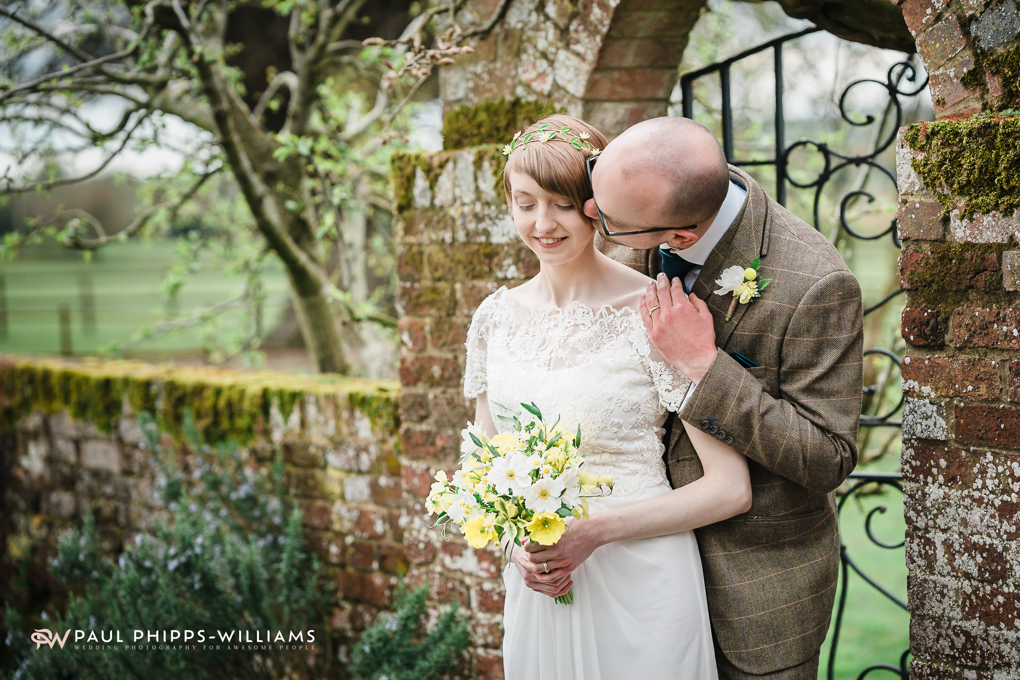 Couple standing by the garden arch at Barford Park Barn