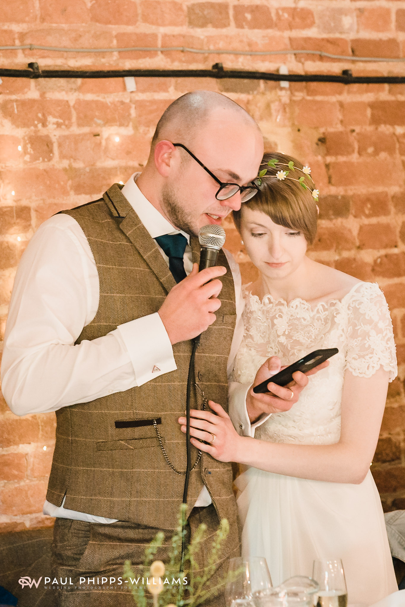 A couple's read a speech from a phone at Barford Park barn