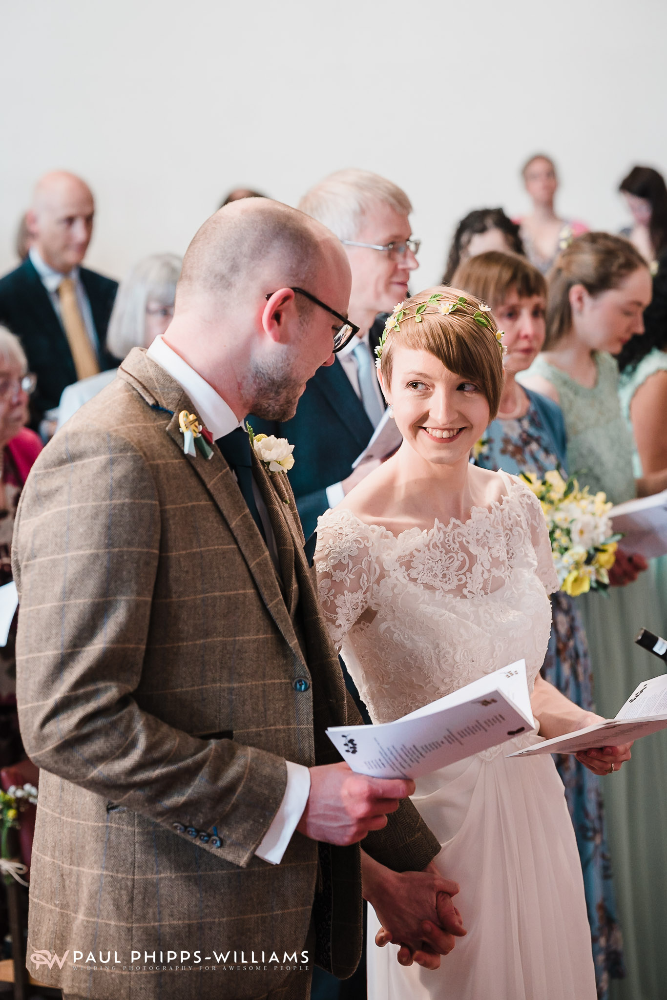 Emily smiles at Sim during a hymn.