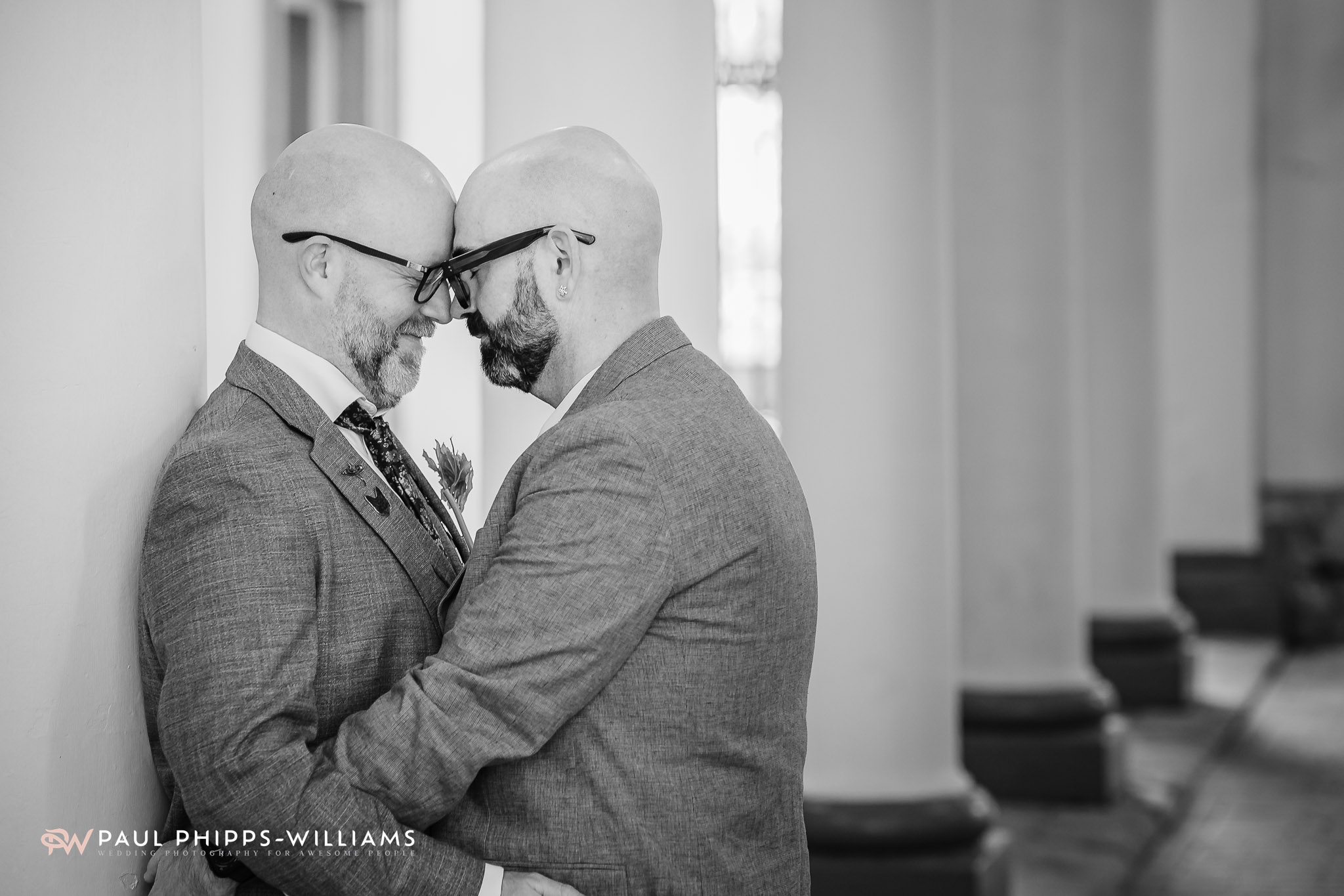 Two grooms touch foreheads by the cloisters in Derby Market
