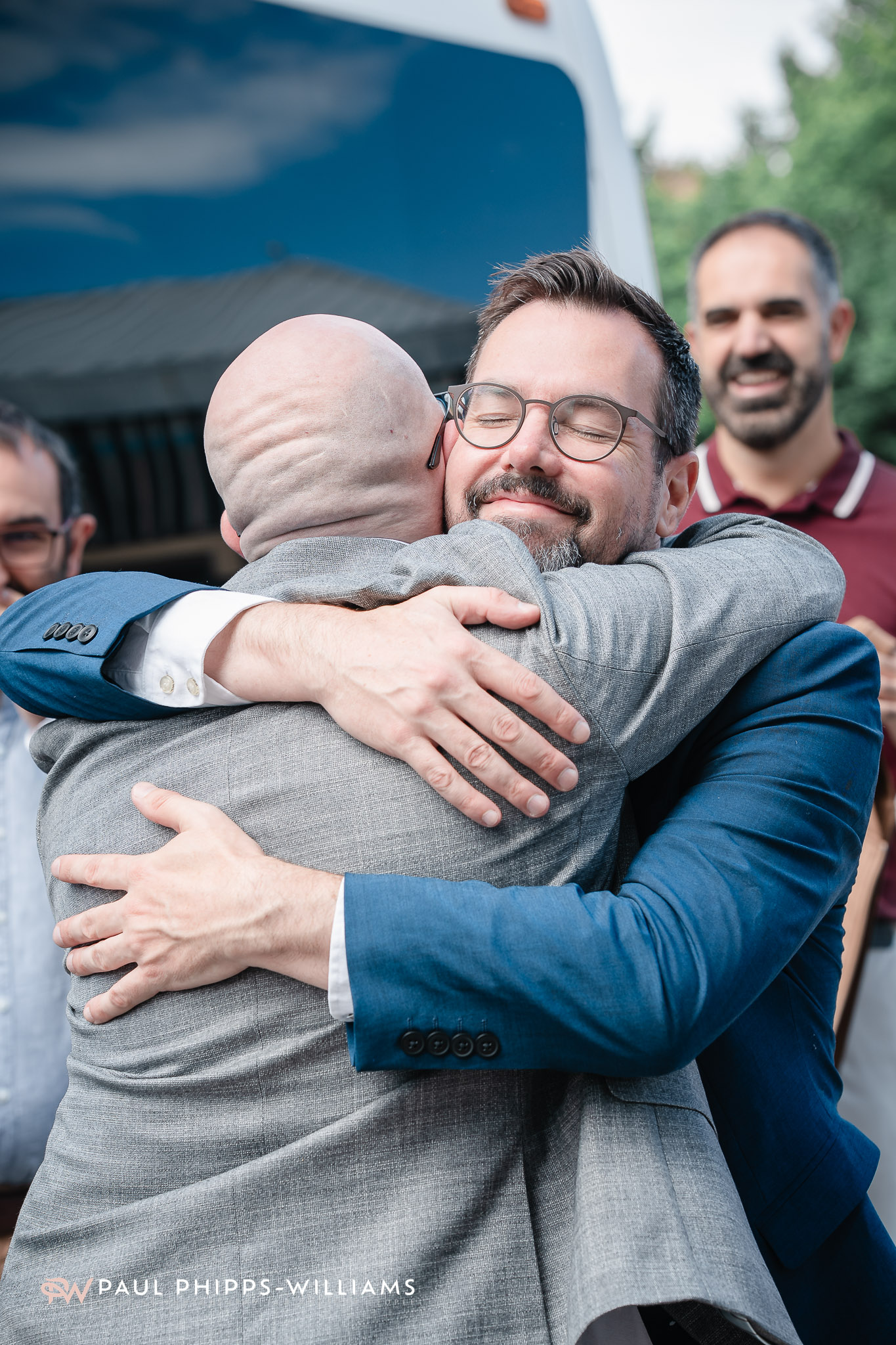 A wedding guest hugs a groom outside Derby Registry Office