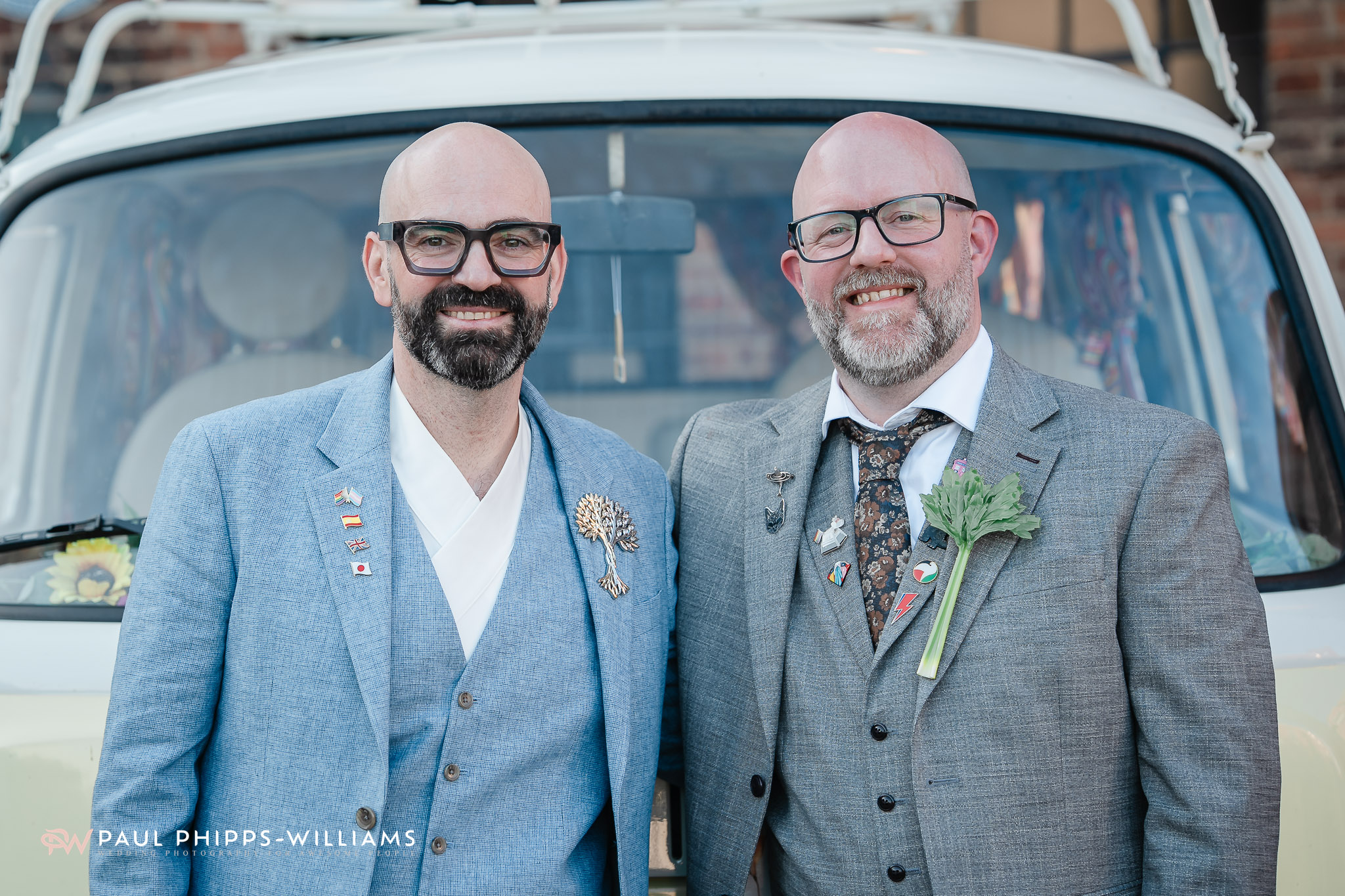 Two grooms in front of a VW Camper van outside the Museum of Making