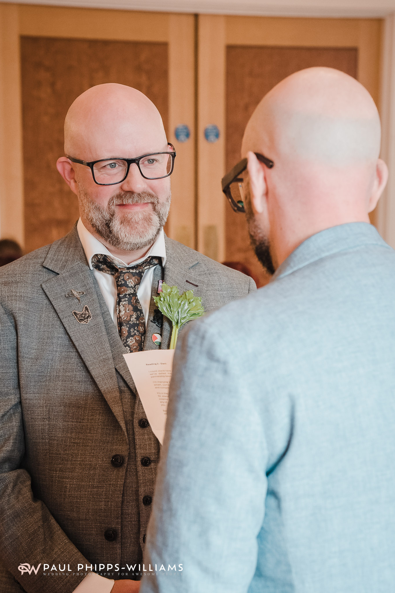 A groom listens to his future husband read his vows at Derby Registry Office