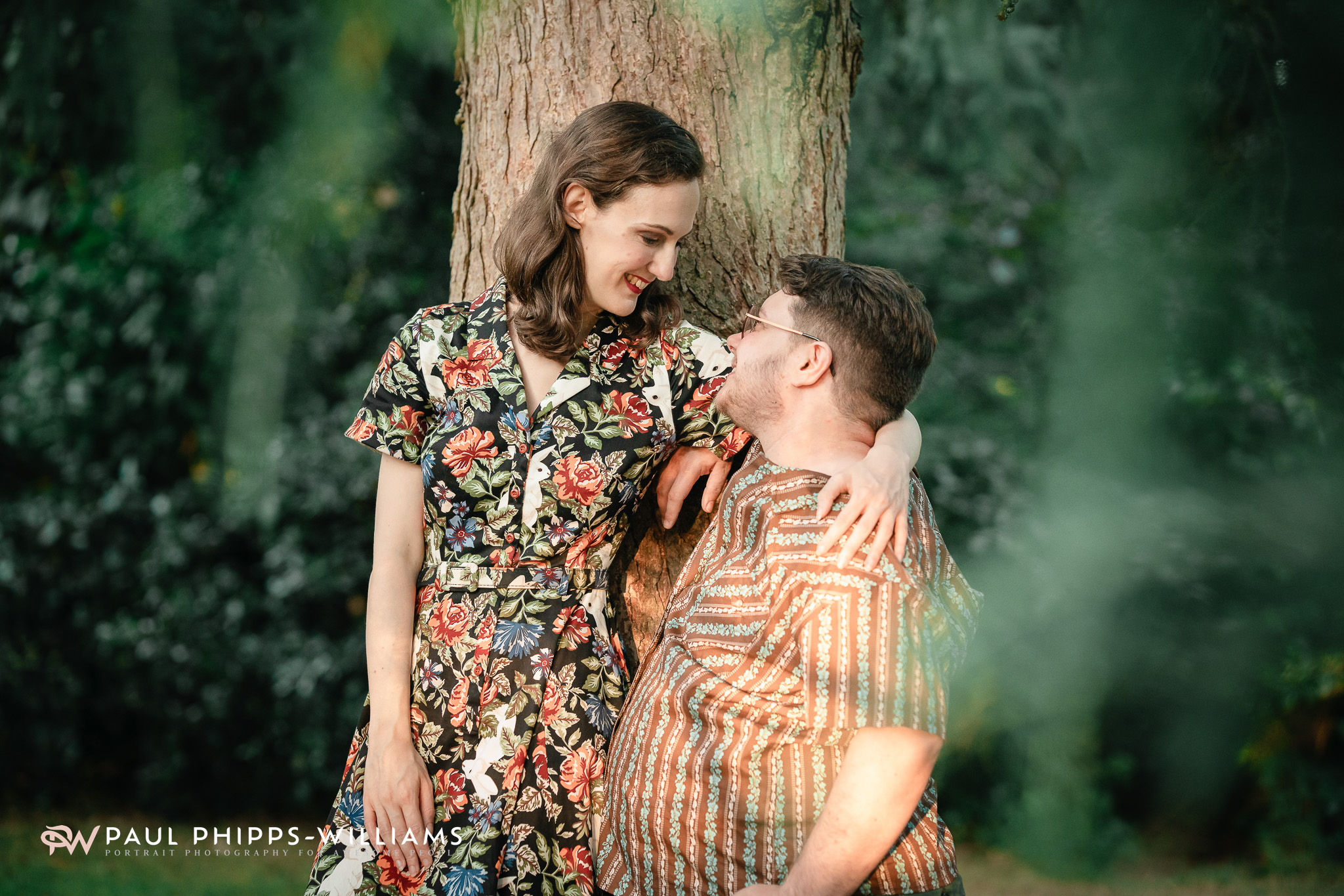 Georgia holds Fio, a trans man and Manchester writer, by a tree in soft golden light