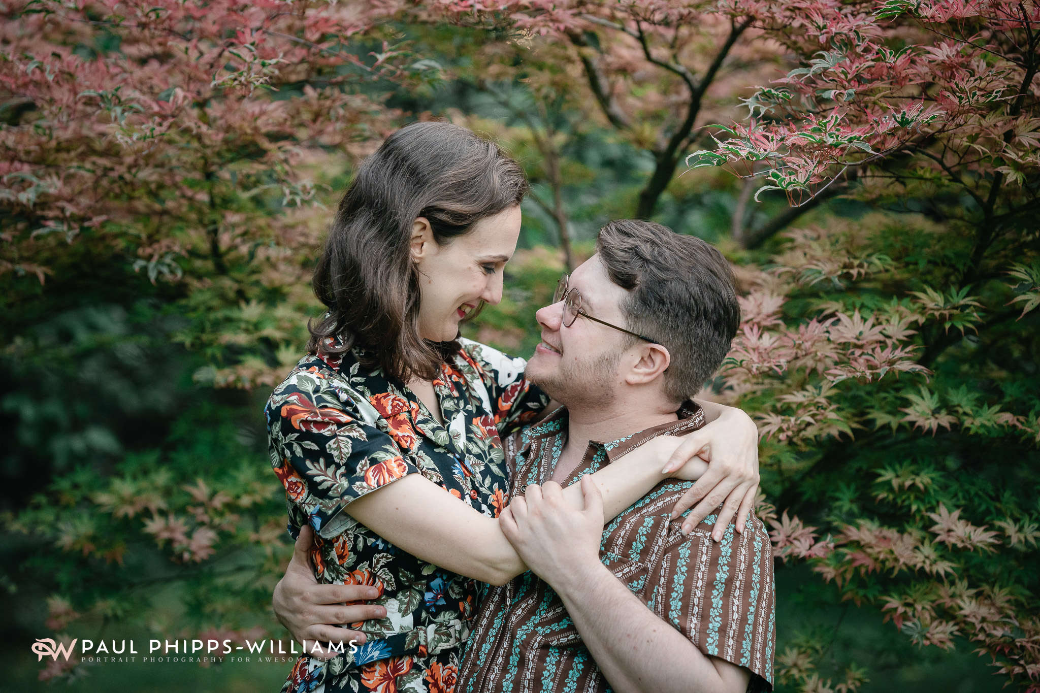 Fio and Georgia hug in front of autumn trees in Manchester