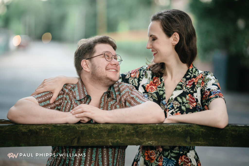 Georgia with her arm around Fio, a trans man and Manchester writer, at a gate to their local park