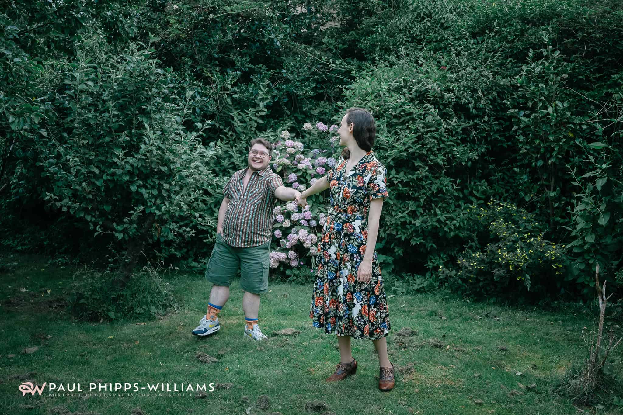 Joyful family portrait in a vibrant garden with lush greenery and blooming flowers, capturing happin.