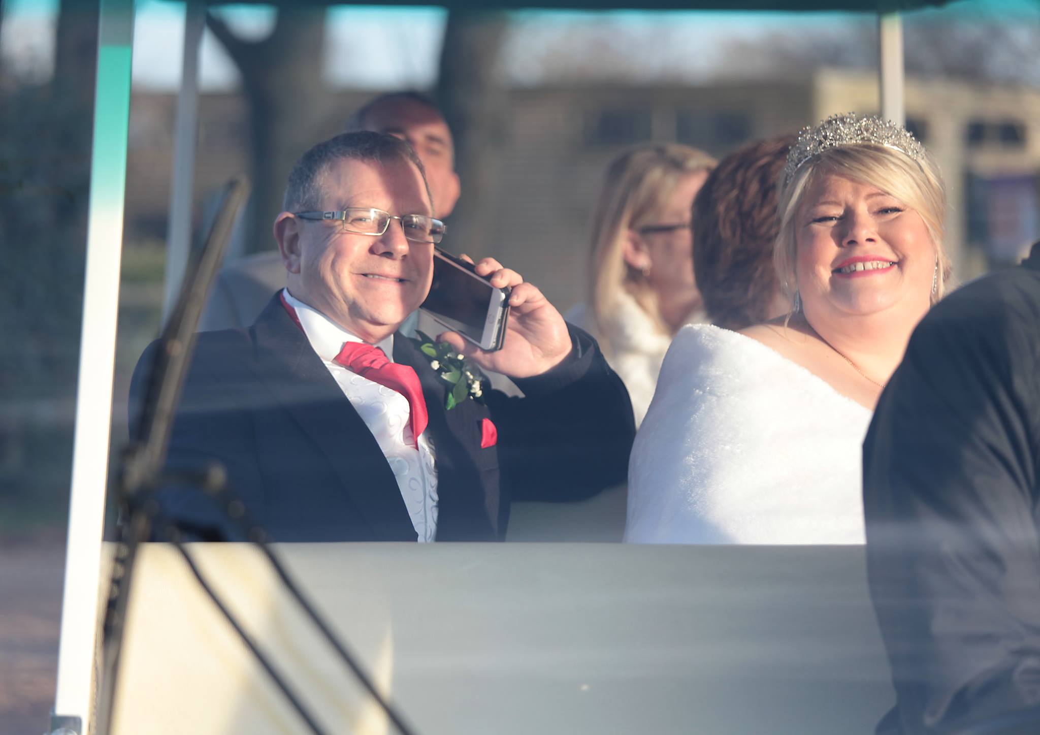 A winter wedding at Twycross Zoo in the West Midlands - a couple in a golf buggy wrapped up