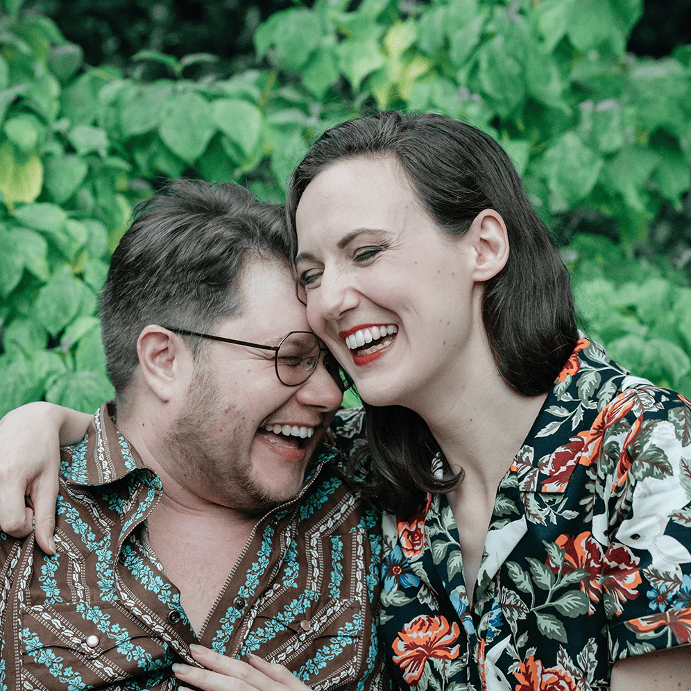 Wedding joy with a happy couple laughing outdoors in vibrant floral shirts.