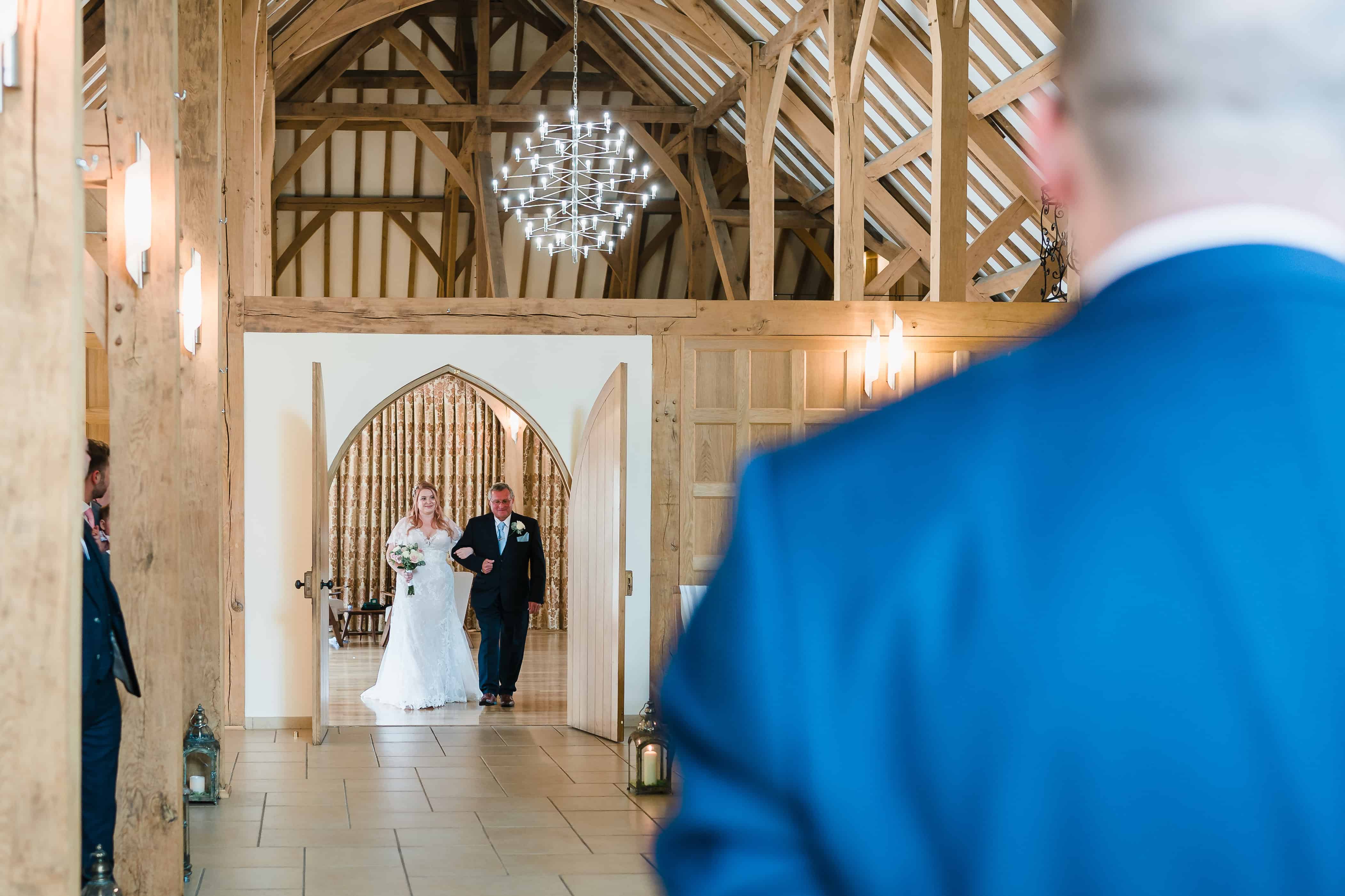 a bride coming down the aisle at Rivervale Barn