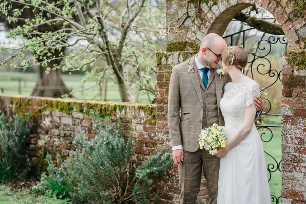bride and groom by a stone gate during their midlands wedding