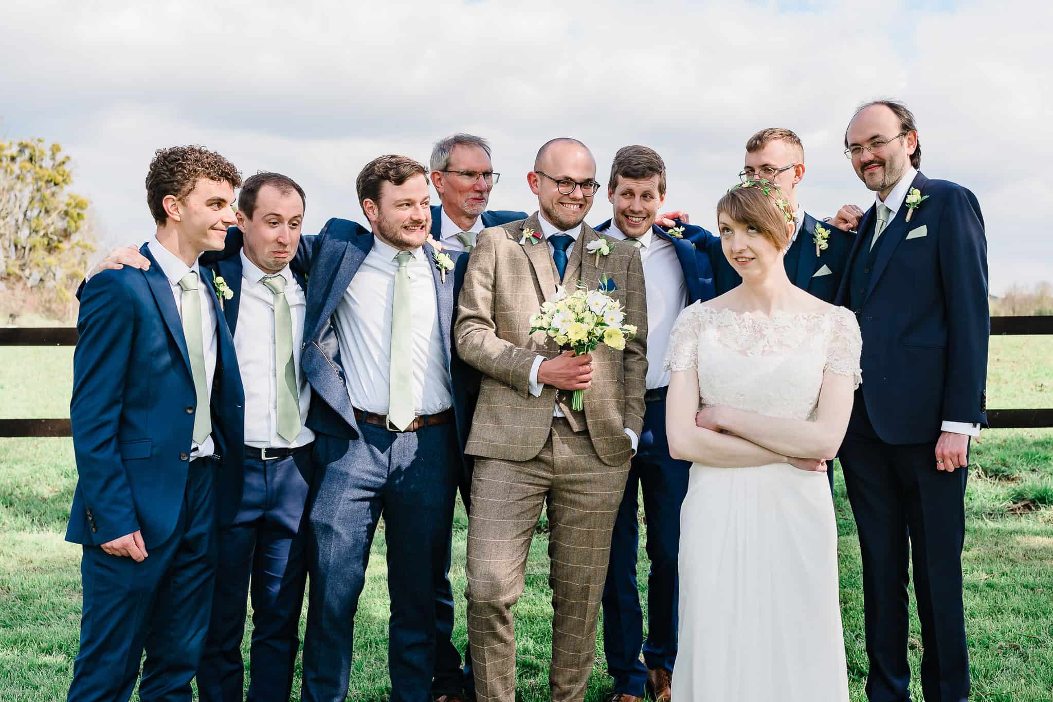 a bride rolls her eyes as a groom's wedding party look apologetic