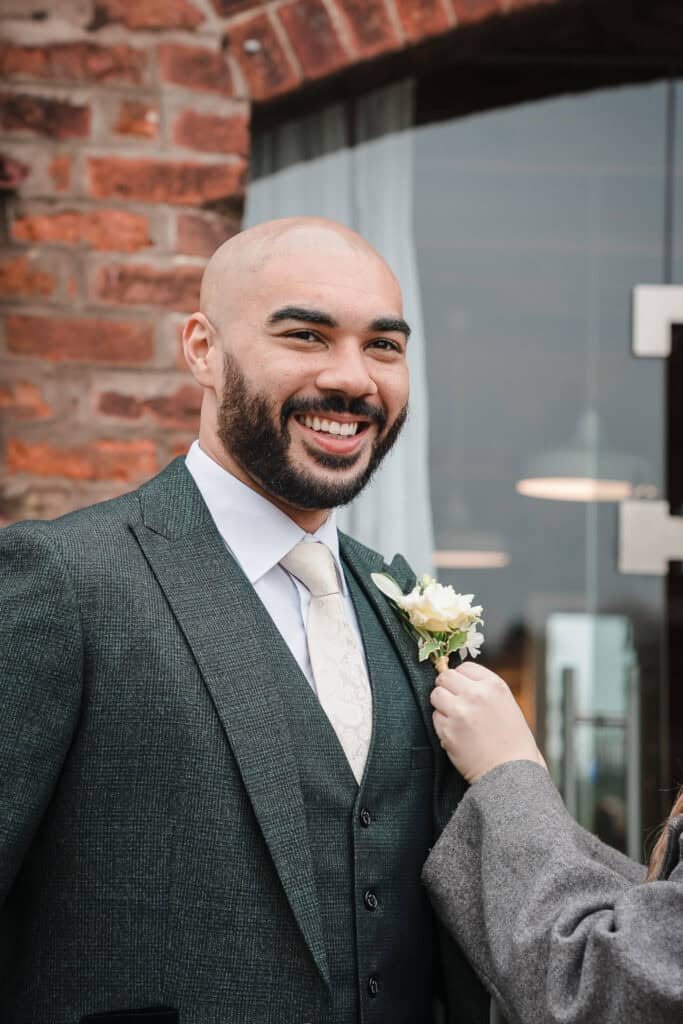 a groom smiles at a registry office wedding in the West Midlands